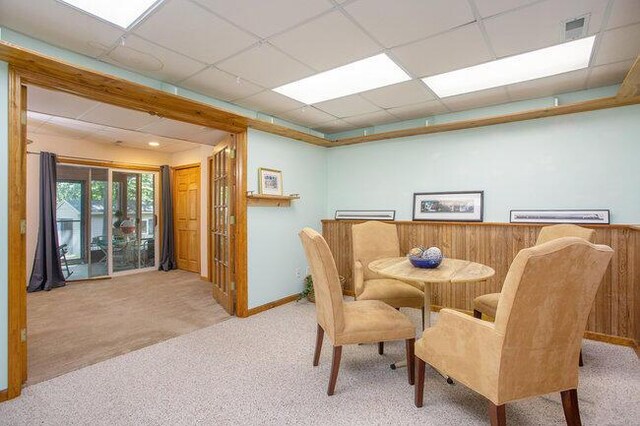 dining area featuring a paneled ceiling and carpet flooring