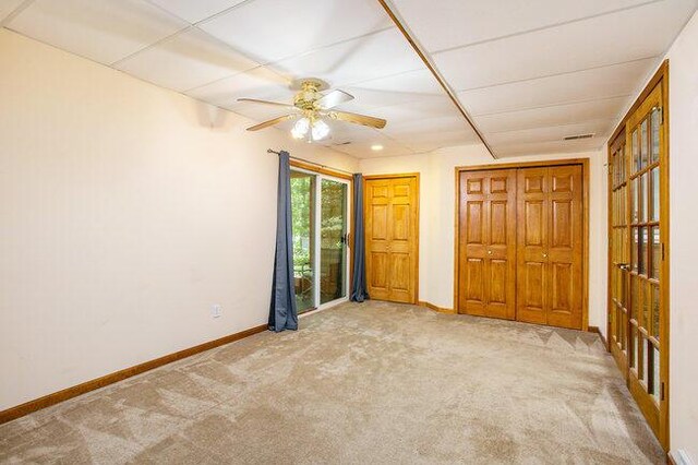 unfurnished bedroom featuring light carpet and ceiling fan