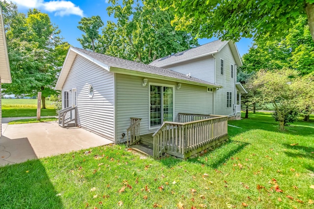 back of property featuring a patio area, a lawn, and a wooden deck