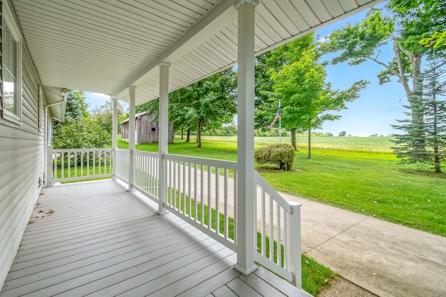 wooden deck featuring a porch and a yard