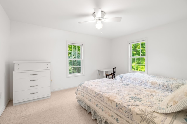 carpeted bedroom featuring ceiling fan and multiple windows