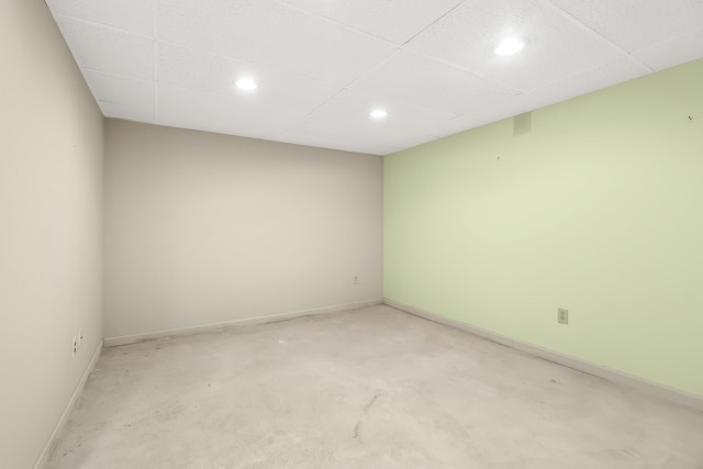 empty room featuring concrete flooring and a drop ceiling