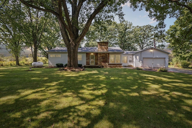 ranch-style house featuring a front lawn, an attached garage, driveway, and a chimney