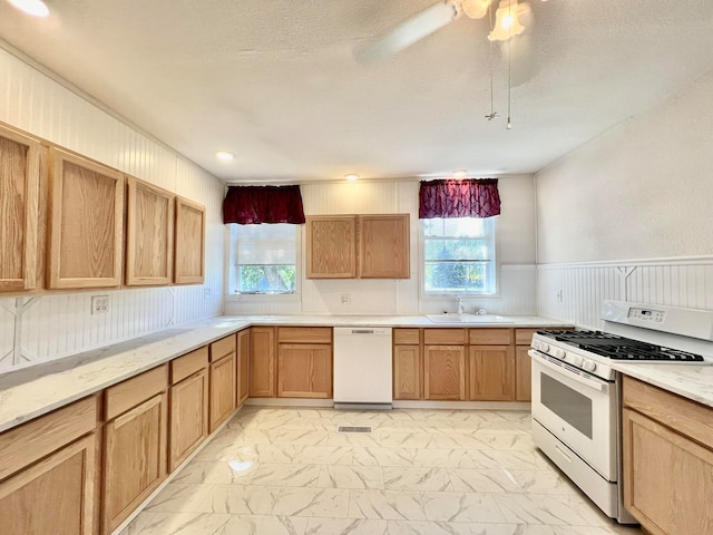 kitchen featuring white appliances, sink, ceiling fan, and a textured ceiling