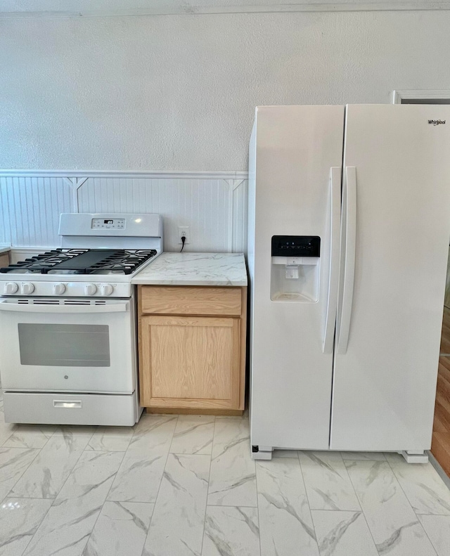 kitchen featuring white appliances and light brown cabinets