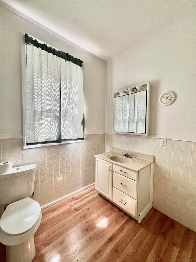 bathroom with vanity, toilet, tile walls, and wood-type flooring