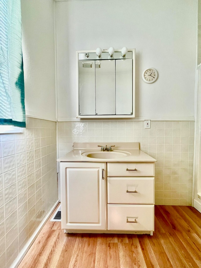 bathroom featuring tile walls, wood-type flooring, and vanity