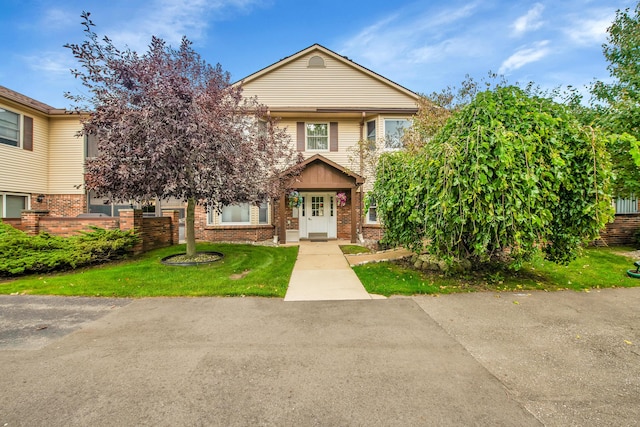 view of front of property featuring brick siding and a front lawn