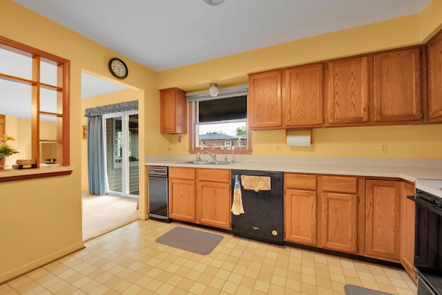 kitchen featuring a sink, light countertops, stove, dishwasher, and brown cabinets