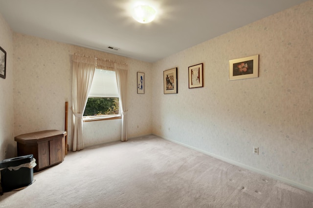 unfurnished room featuring visible vents, baseboards, carpet flooring, and wallpapered walls