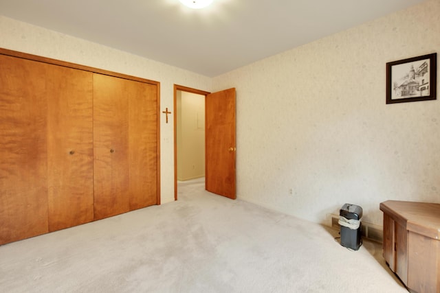 bedroom featuring a closet, carpet flooring, and wallpapered walls