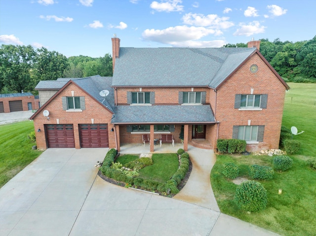 view of front facade with a front yard, brick siding, driveway, and a chimney