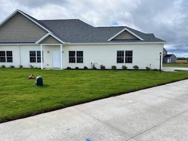 view of front of house featuring a front yard and roof with shingles