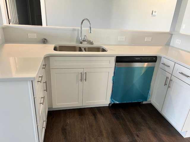 kitchen featuring dark wood-type flooring, a sink, white cabinets, light countertops, and dishwashing machine