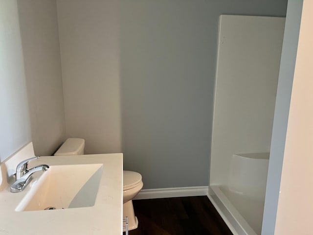 bathroom with a sink, baseboards, toilet, and wood finished floors