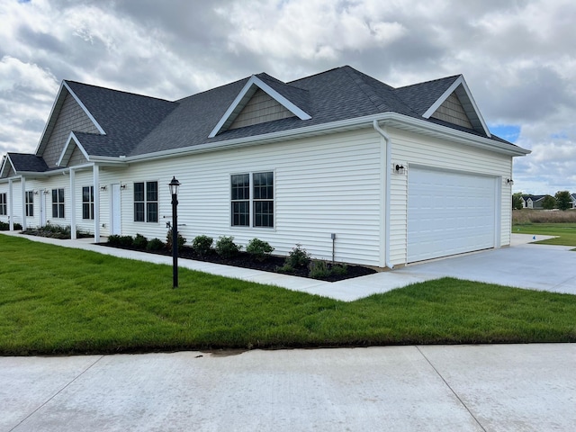 view of front of home with a garage, concrete driveway, a front lawn, and roof with shingles