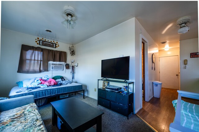 living room featuring dark wood-type flooring, ceiling fan, and cooling unit