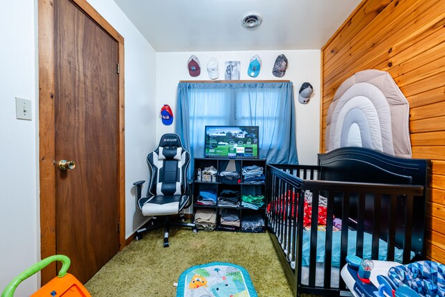 carpeted bedroom with a nursery area and wooden walls