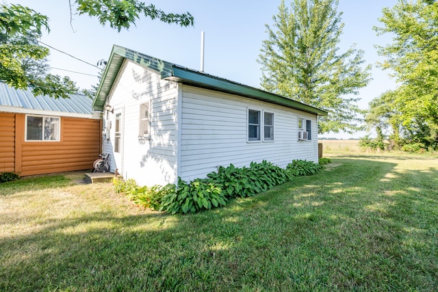 view of side of property featuring cooling unit and a lawn