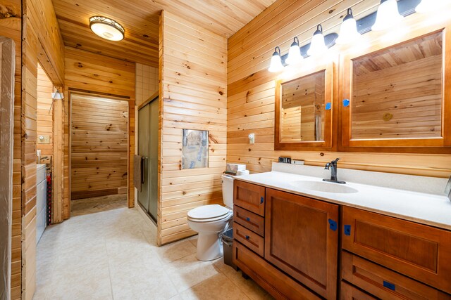 bathroom with vanity, a shower with shower door, wood walls, and toilet