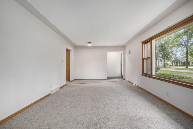 empty room with visible vents, baseboards, and carpet