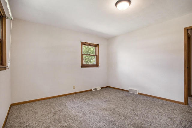 spare room with visible vents, carpet flooring, and baseboards