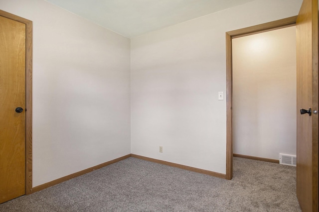 carpeted empty room featuring visible vents and baseboards