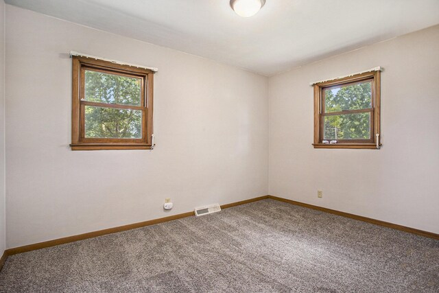 empty room featuring baseboards, carpet floors, and visible vents