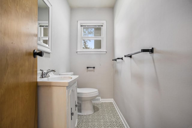 bathroom featuring vanity, toilet, visible vents, and baseboards