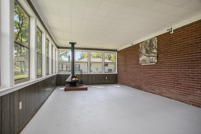 unfurnished sunroom featuring a wood stove