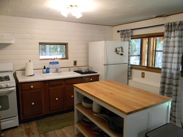 kitchen featuring dark wood-type flooring, white appliances, wooden walls, and wood counters