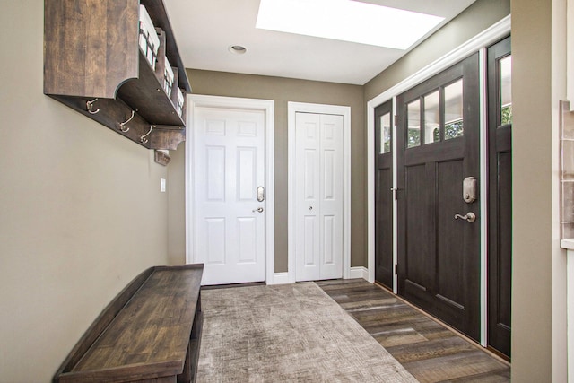 foyer featuring dark wood-type flooring and a skylight