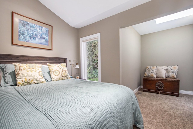 carpeted bedroom featuring vaulted ceiling with skylight