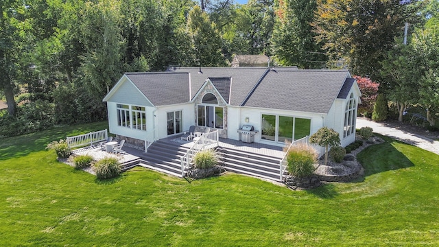 back of property featuring a wooden deck and a lawn