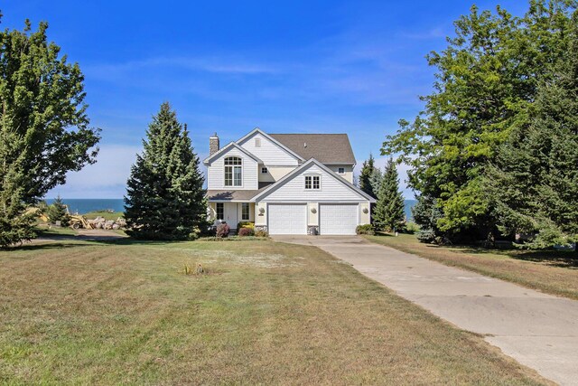 view of front of house featuring a front yard, a water view, and a garage