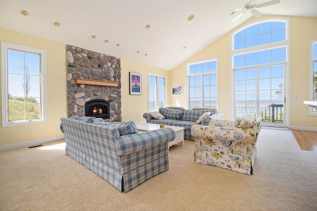 living room featuring a fireplace, light wood-type flooring, lofted ceiling, and ceiling fan