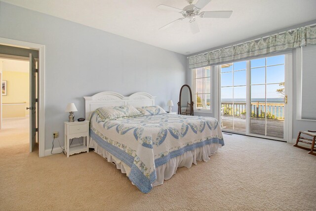 carpeted bedroom featuring ceiling fan, a water view, and access to outside