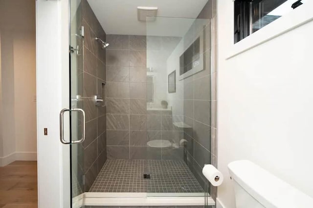 bathroom with walk in shower, wood-type flooring, and toilet