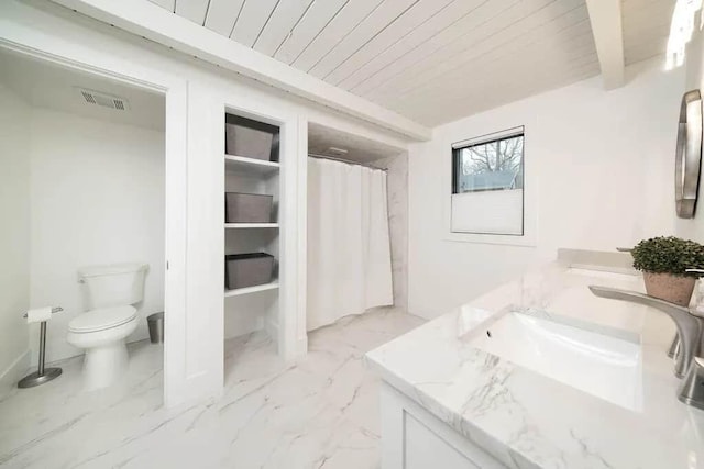 bathroom featuring wooden ceiling, beam ceiling, vanity, and toilet