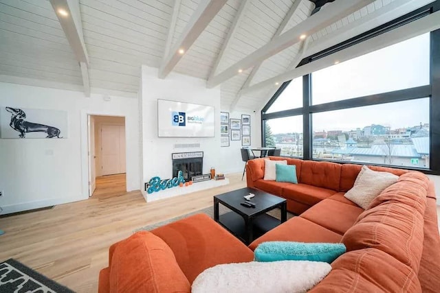 living room featuring high vaulted ceiling, light wood-type flooring, and beam ceiling