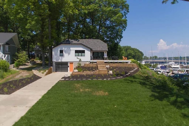 view of front of property with a water view, a garage, and a front yard