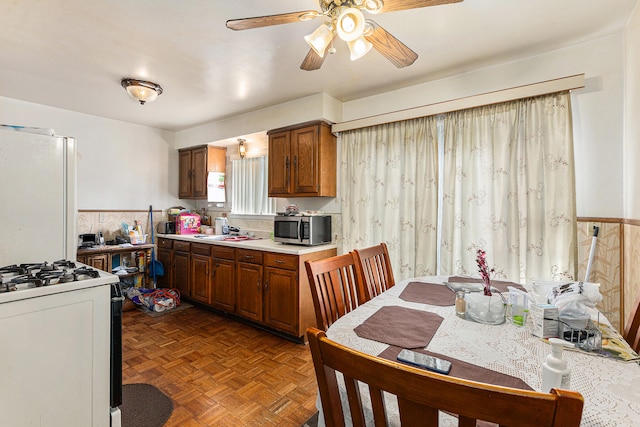 kitchen with light parquet floors, ceiling fan, and white appliances