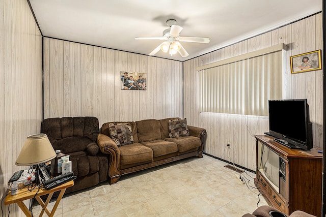 living room featuring ceiling fan and wooden walls