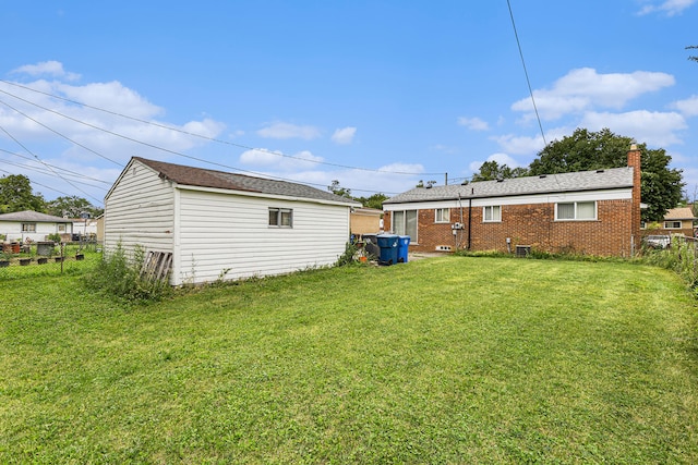 back of house with a lawn and an outbuilding