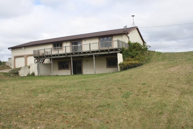 back of house featuring a lawn and a balcony