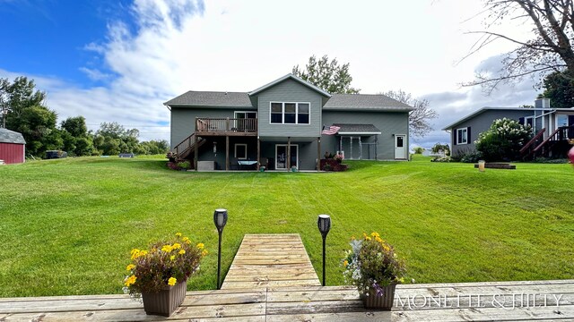 back of house with a lawn and a deck