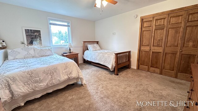 bedroom with a closet, ceiling fan, and light colored carpet