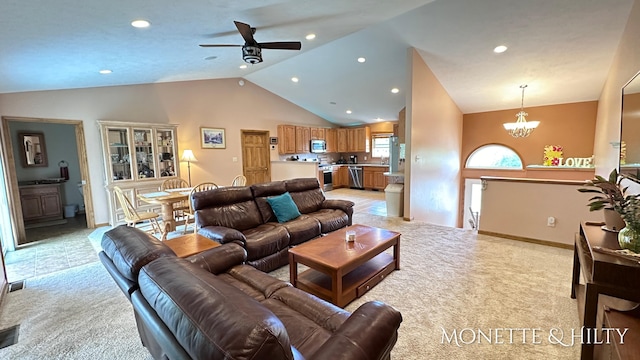 carpeted living room featuring ceiling fan with notable chandelier and high vaulted ceiling