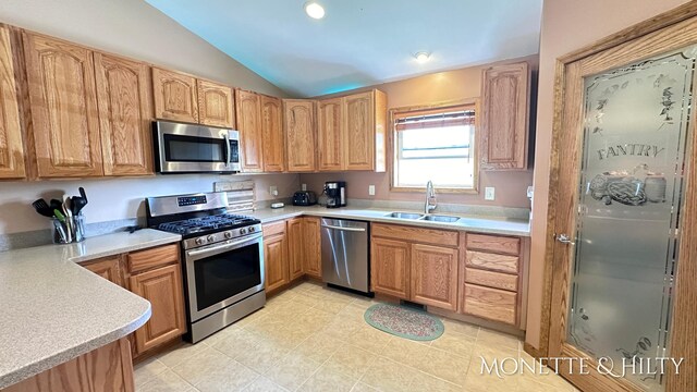 kitchen featuring lofted ceiling, sink, and appliances with stainless steel finishes