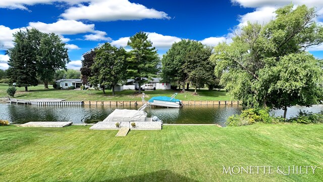 view of dock with a water view and a yard